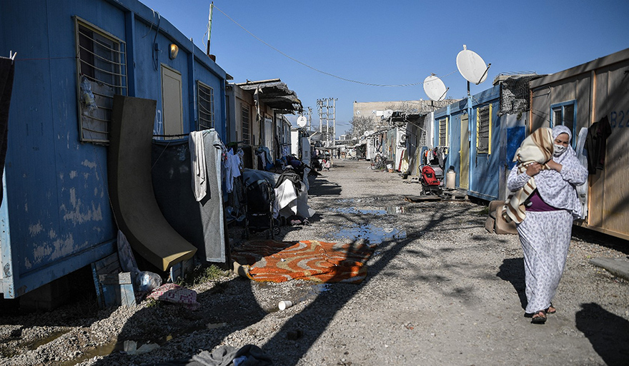 Une femme porte son bébé au camp de réfugiés d'Eleonas à Athènes, le 9 février 2022