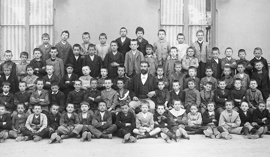 Ripresa in esterno. Gruppo di scolari con un maestro, 1900